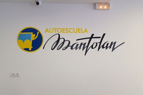 Vinilo tipográfico y logo corporativo sobre pared.
