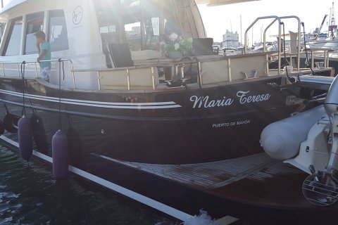 Rotulación que envuelve el barco con doble línea blanca y nombre de la nave María Teresa.