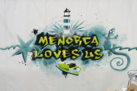 Diseño gráfico de "Menorca Love Us" impreso sobre lona.