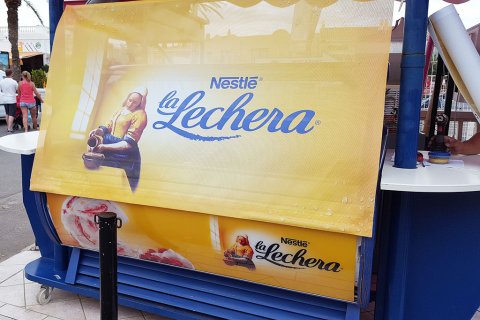 Impresión digital de la marca  "Nestlé La Lechera" sobre lona para tapar un puesto de helados.